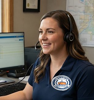 Claire, Lansing Dumpster Co dispatcher, taking a booking in the office