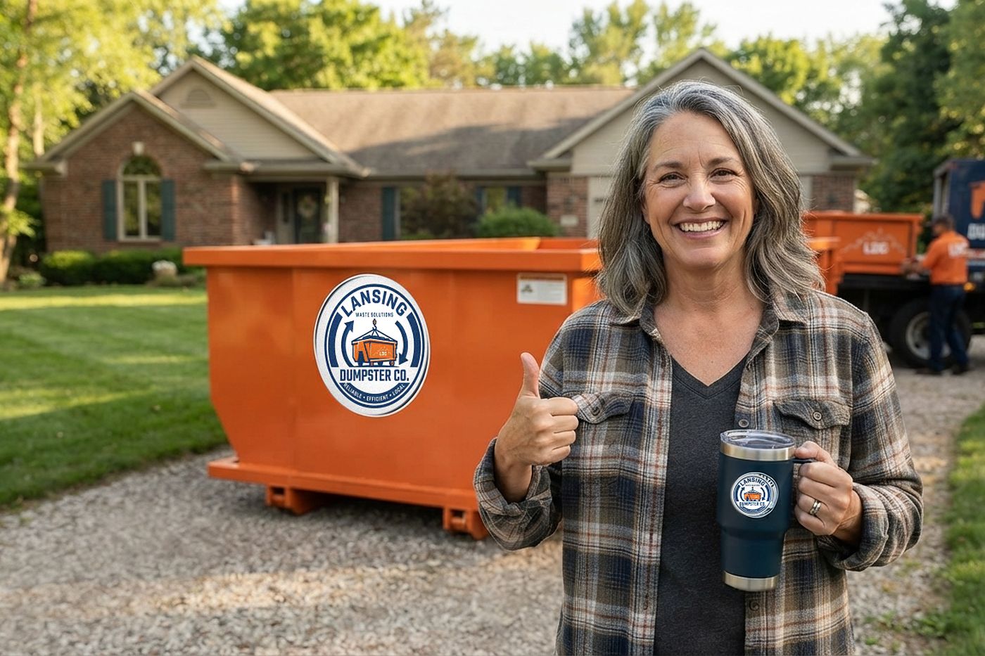 A Lansing homeowner beside her Lansing Dumpster Co roll-off container on the driveway